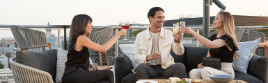 A group of friends having drinks on the rooftop of a hilton hotel
